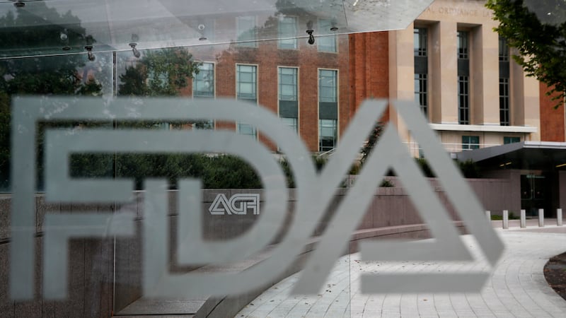 FILE - The U.S. Food and Drug Administration building stands behind an FDA logo at a bus stop...