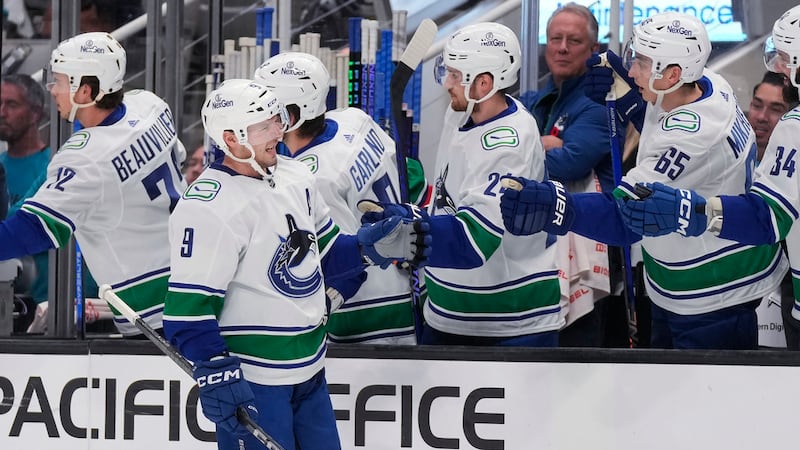 Vancouver Canucks center J.T. Miller (9) is congratulated by teammates for his goal against...
